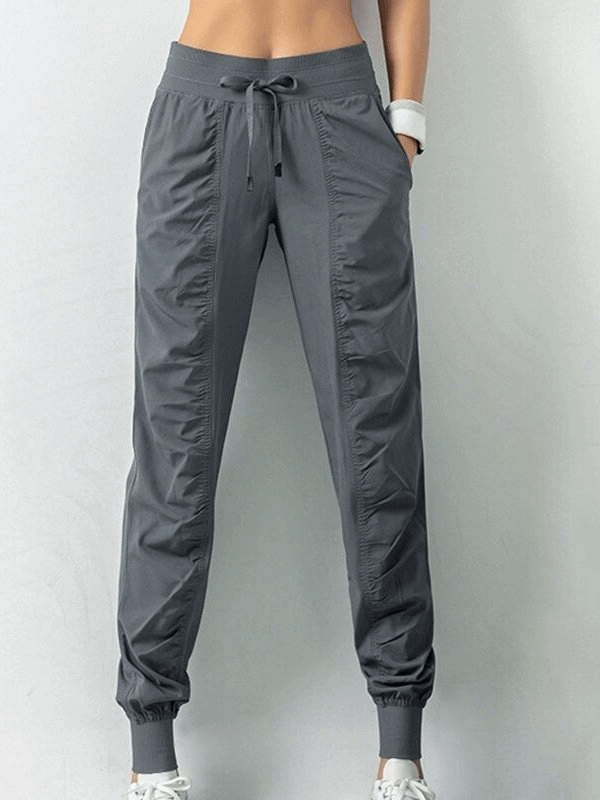 Women's Sports Joggers SF0177 with side pockets and cuffs, gray color, polyester, drawstring waist, loose fit, stylish and comfy.